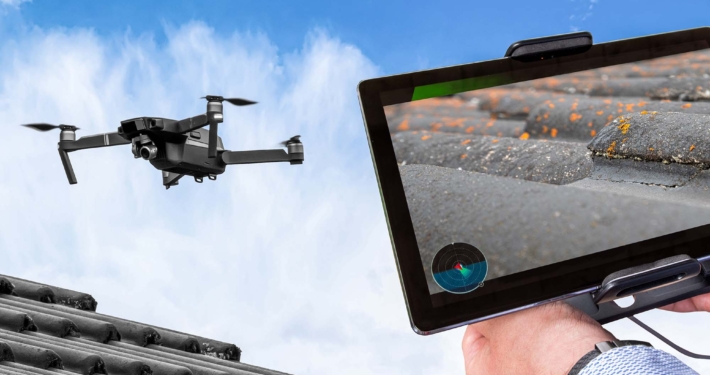 Drone in the air inspecting the roof over the house. Close-up of drone and roof