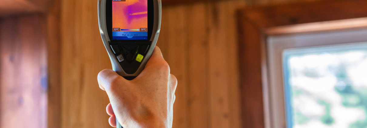 A close up view on the rear screen of an infrared thermovision camera in the hand of a home inspector