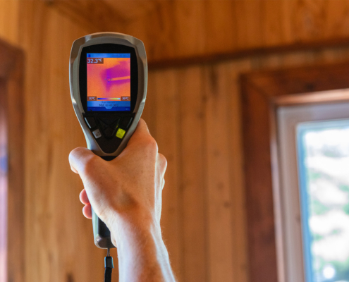 A close up view on the rear screen of an infrared thermovision camera in the hand of a home inspector