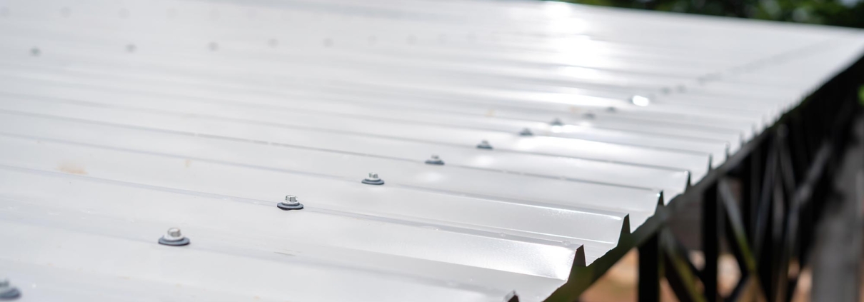 Side view of white PU foam metal roof on black steel structure in construction site
