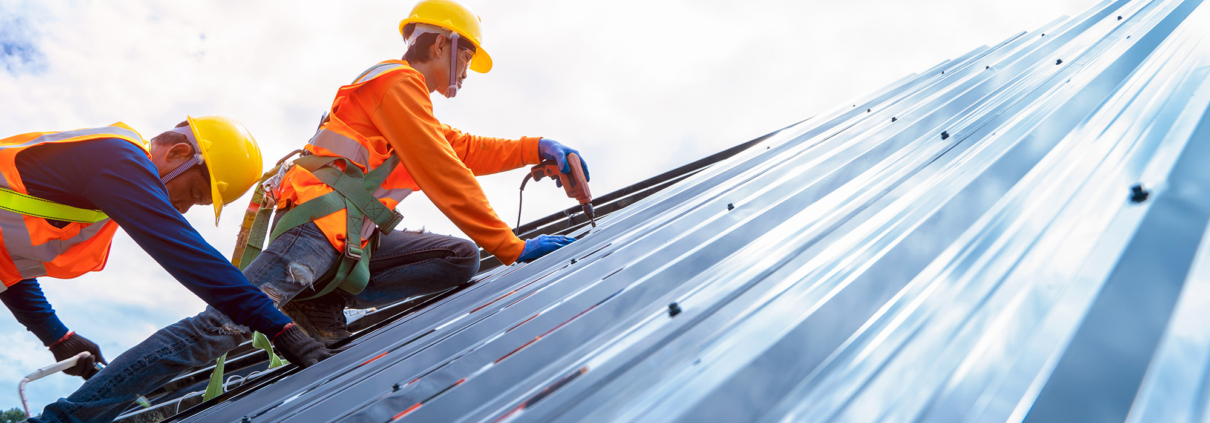 Portrait of technician is installing new roofs under construction