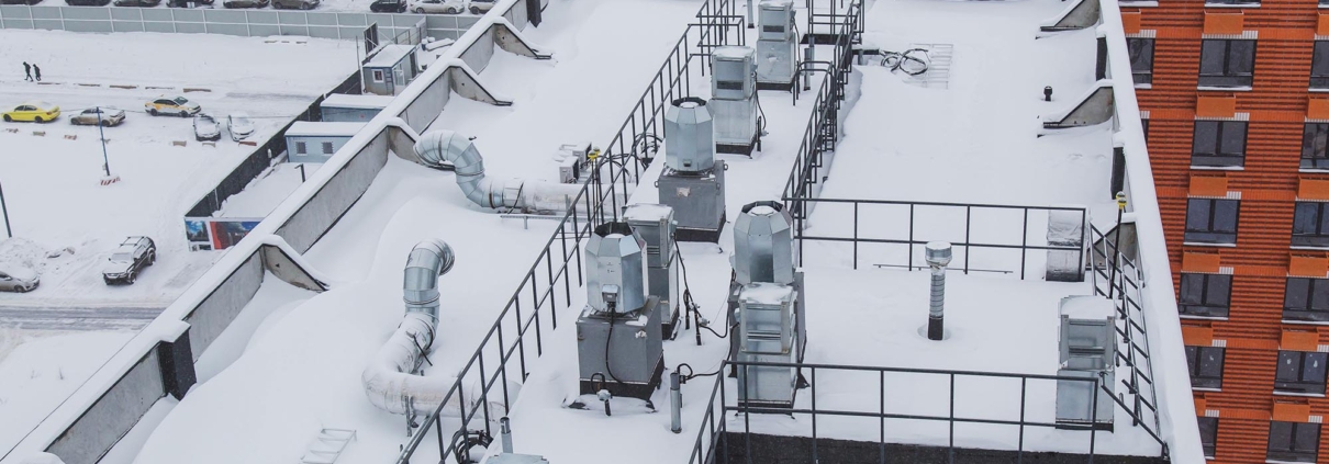 snow-covered roof with ventilation of a new high-rise apartment building