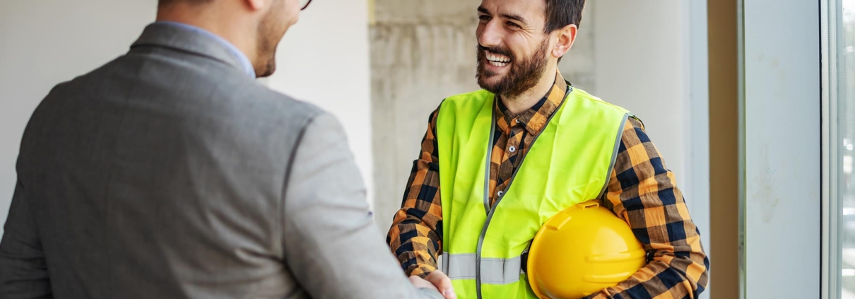 Business person shaking hands with roofer