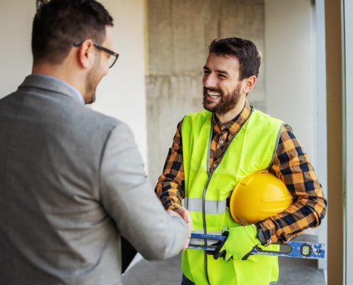 Business person shaking hands with roofer